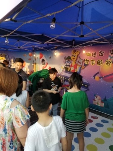 Kids and their parents drawn by the colourful booth of the Harold